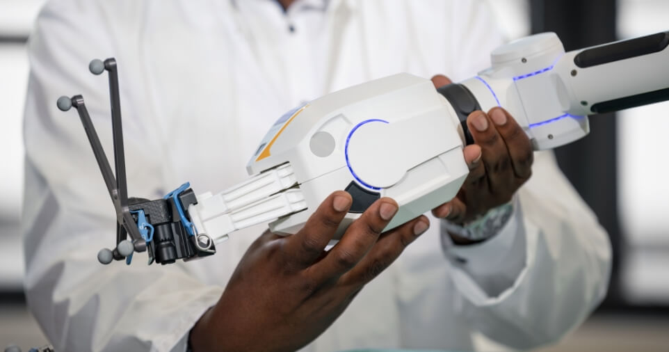 Person holding a medical robotic device during Brainlab onsite training.