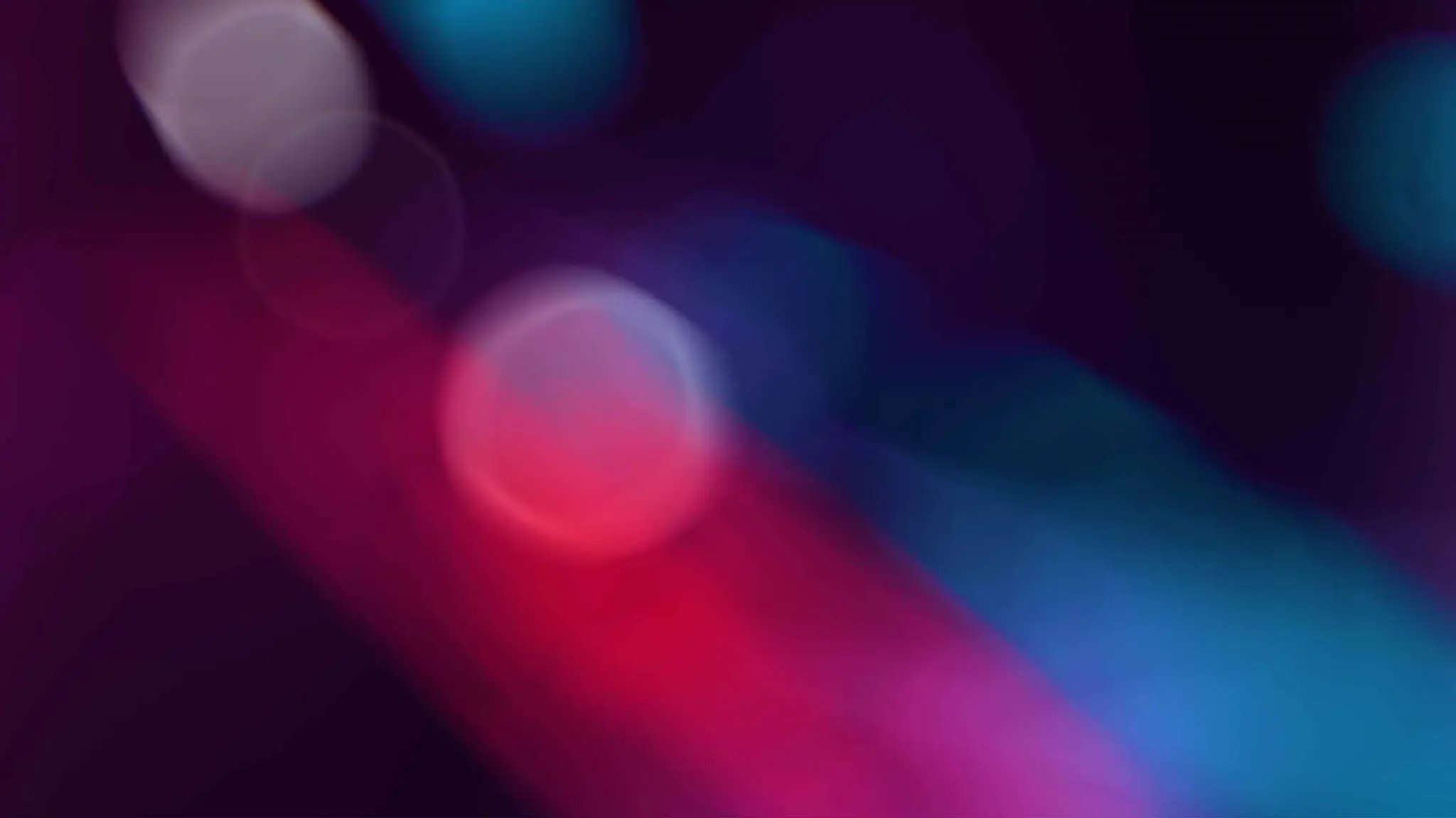 Blurred colors in red, blue, and purple hues.