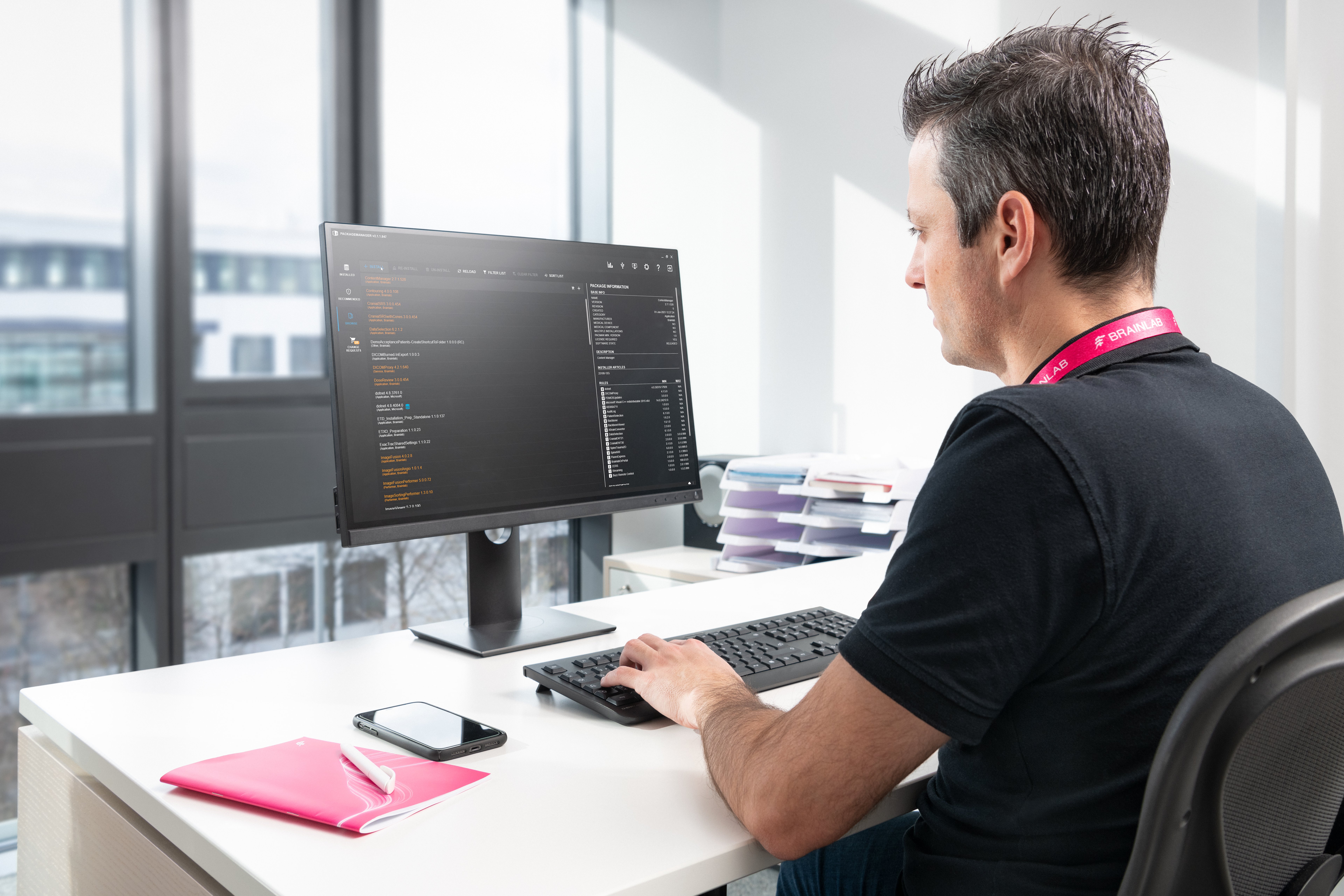 Brainlab service and support employee working on a computer while sitting at a desk