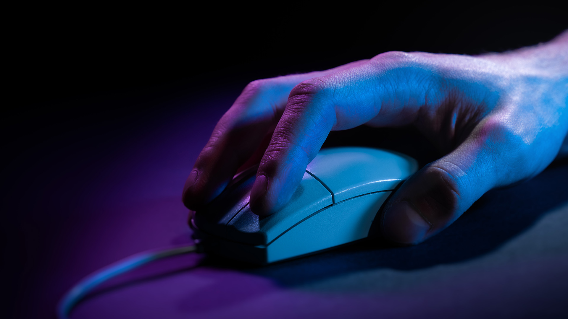 A hand rests on a computer mouse